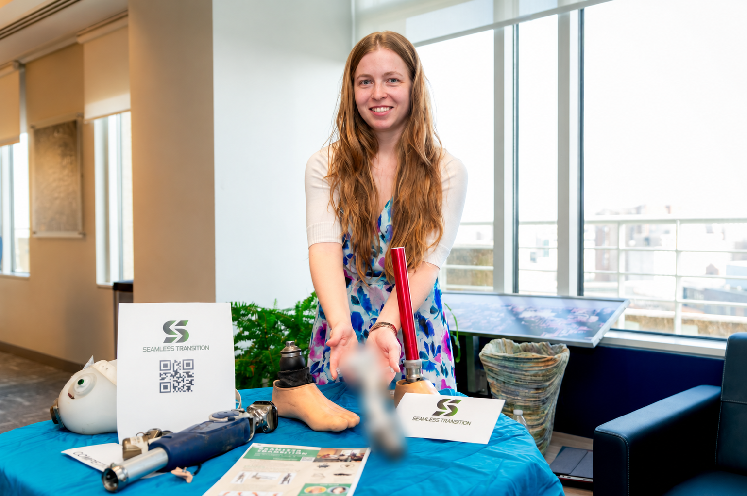 Sarah Malinowski holding a deliberately blurred prosthetic knee prototype at a Seamless Transition event.