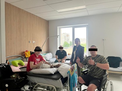 Sarah Malinowski with two people during a hospital visit in Ukraine; faces are obscured for privacy.